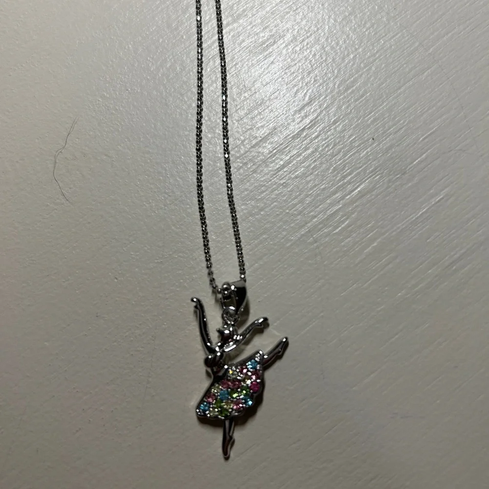 Girls 16” silver necklace with 2” extender. Has a ballerina pendant with stones.